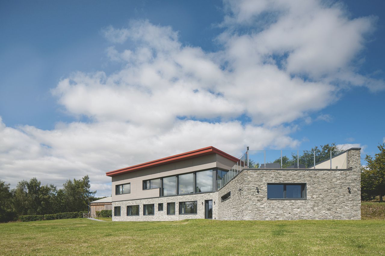 rear of self build house with red roof and stone cladding