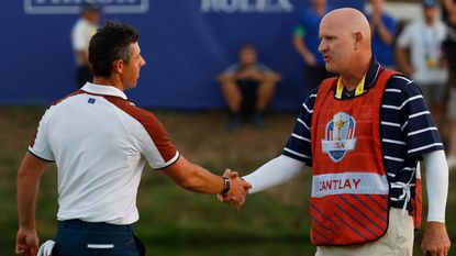 Rory McIlroy and Joe LaCava shake hands after the Saturday afternoon fourball match in the Ryder Cup at Marco Simone