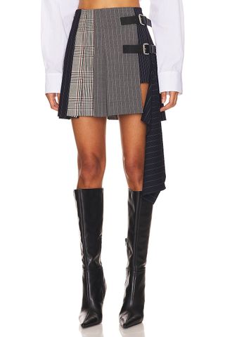 up close shot of Revolve model in plaid mini skirt and tall black boots