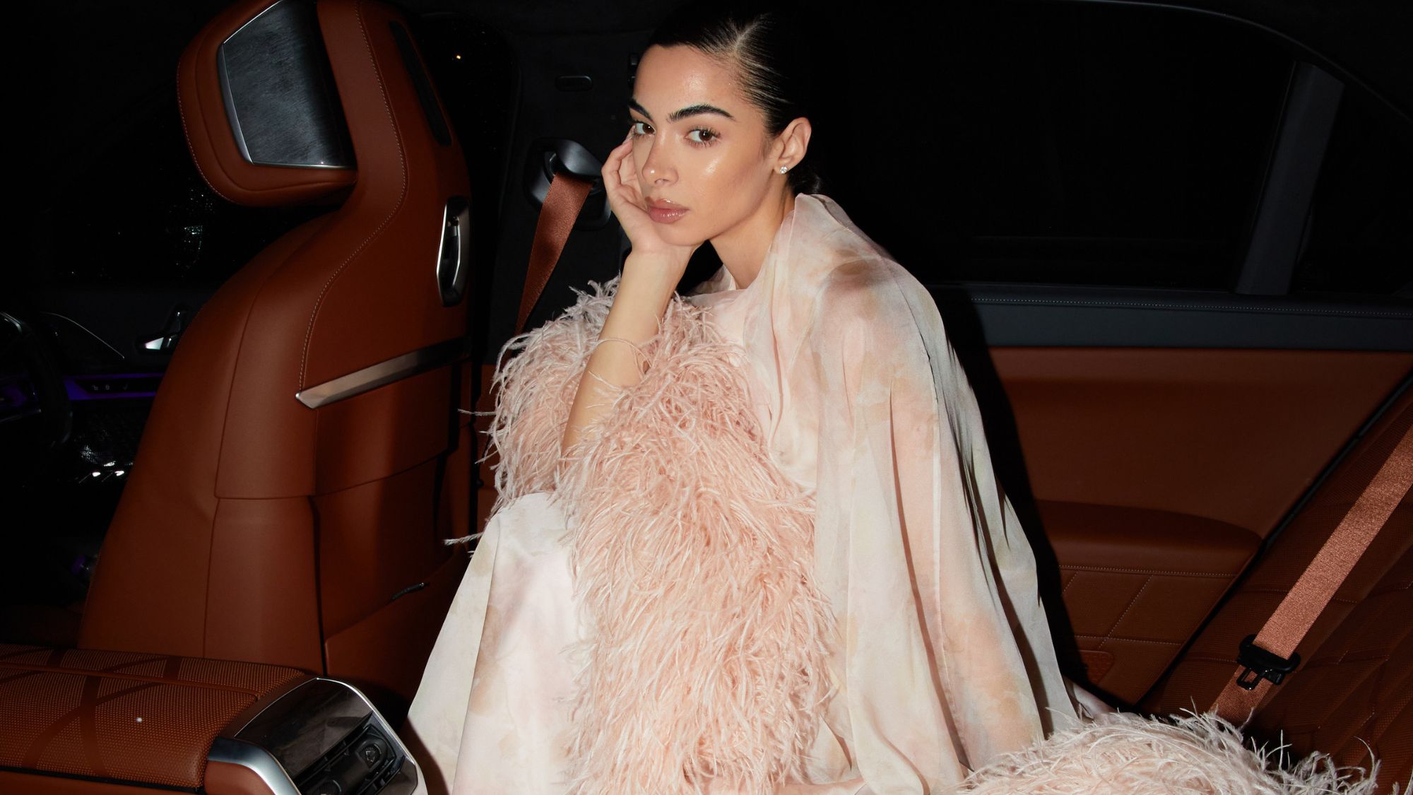 federica labanca wearing a pink feather dress in a car