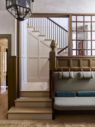 An image looking through to a stairwell with wainscoting and wall paneling