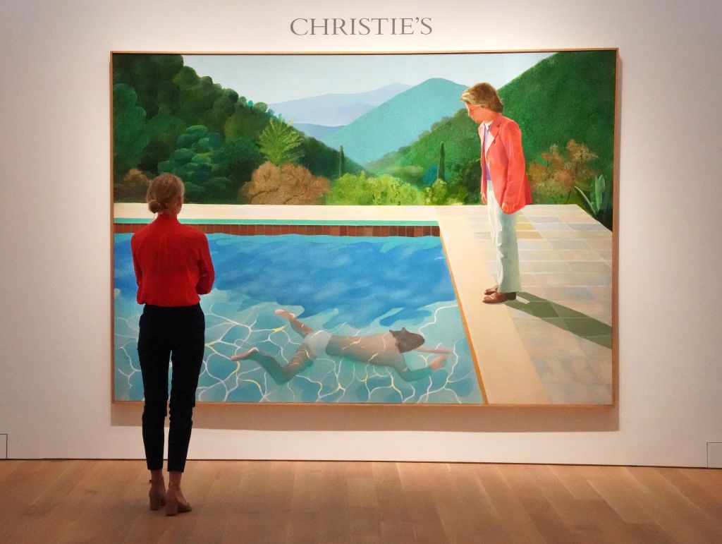 A woman looks at David Hockney's &amp;quot;Portrait of an Artist (Pool with Two Figures)&amp;quot; during a press preview