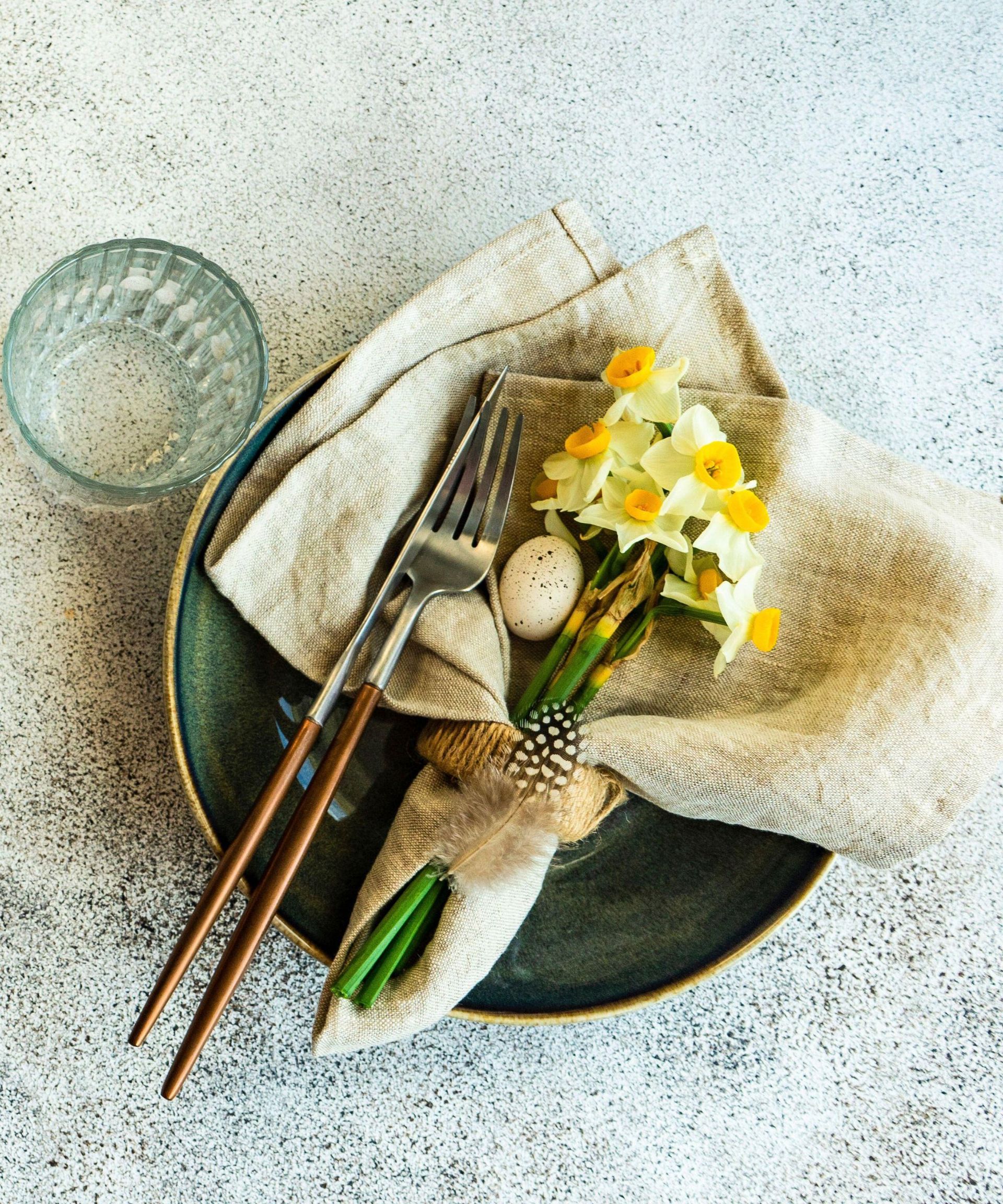 Minimalistic table setting for easter festive dinner decorated with daffodil flowers