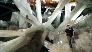The interior of the Cave of Crystals with a geologist in the foreground.