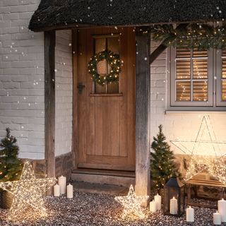 light up wreath garland and stars outside cottage porch