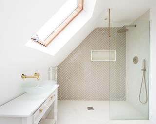 White bathroom with shower, clean tiles and light coming in through angled sky light