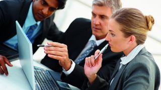 Business people looking at a laptop screen together.