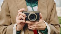 Panasonic Lumix L10 camera in gold held in a pair of hands