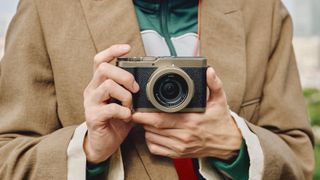 Panasonic Lumix L10 camera in gold held in a pair of hands