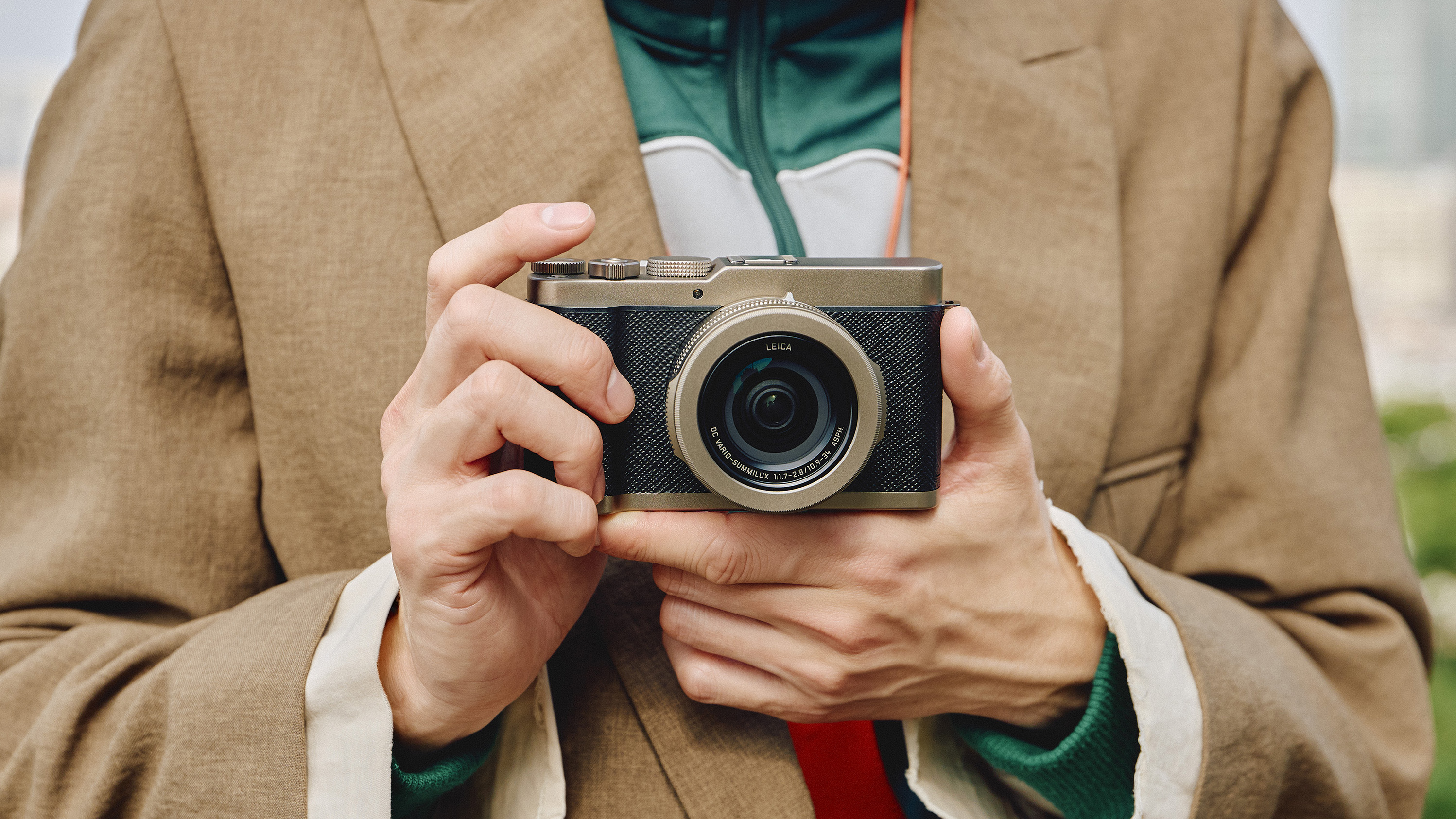 Panasonic Lumix L10 camera in gold held in a pair of hands