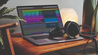 Apple MacBook Pro on a desk with Logic Pro running, along with headphones