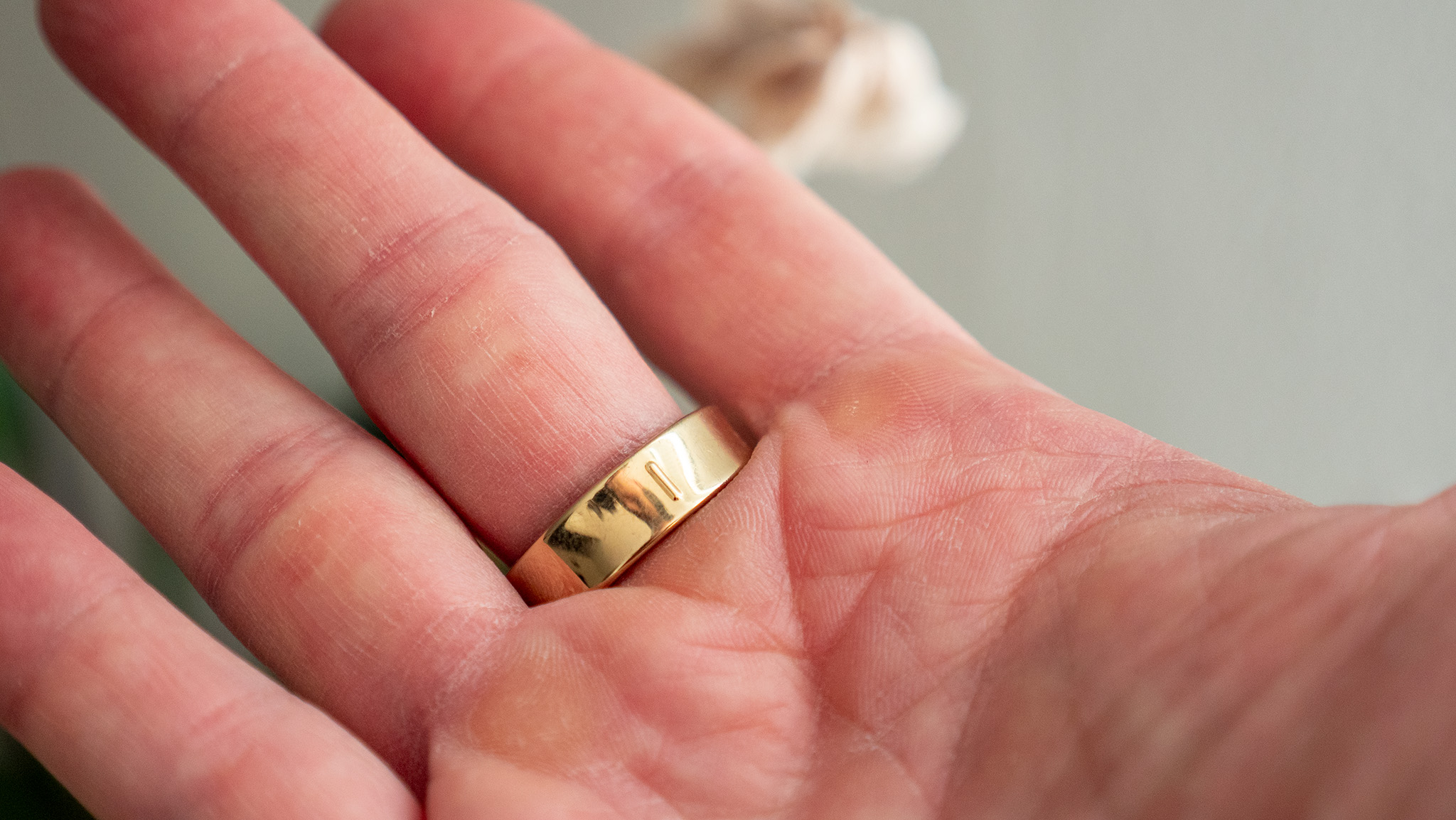 The directional indicator on the underside of the gold Samsung Galaxy Ring while wearing it