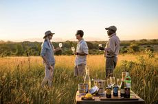 Three people with drinks on safari at Singita in Kruger, South Africa