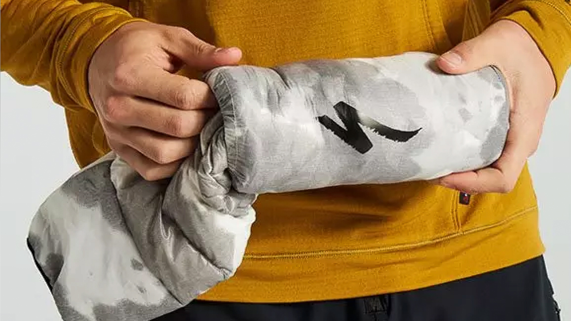 The Specialized Packable Down Jacket being stashed in its storage bag
