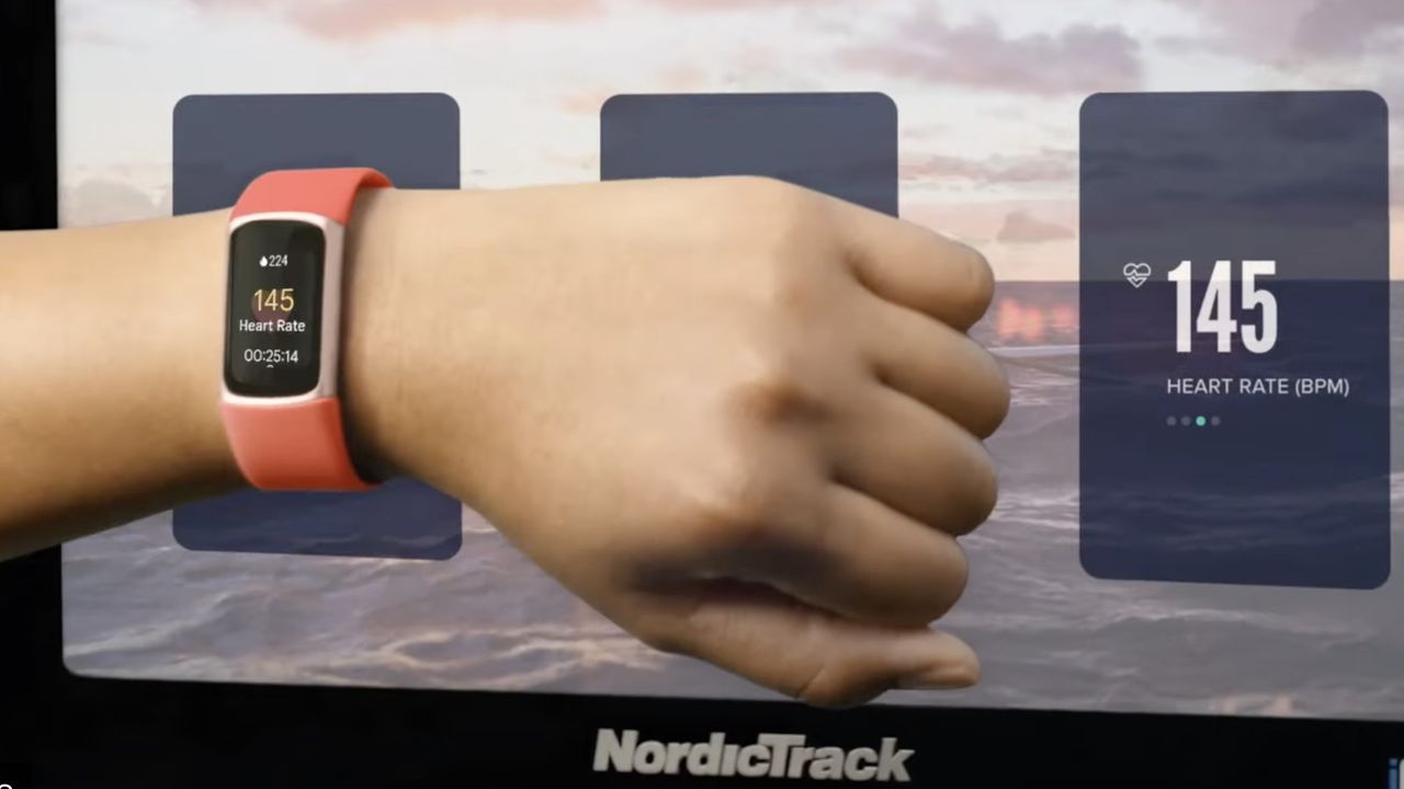 The Fitbit Charge 6 with a red band, worn on a wrist