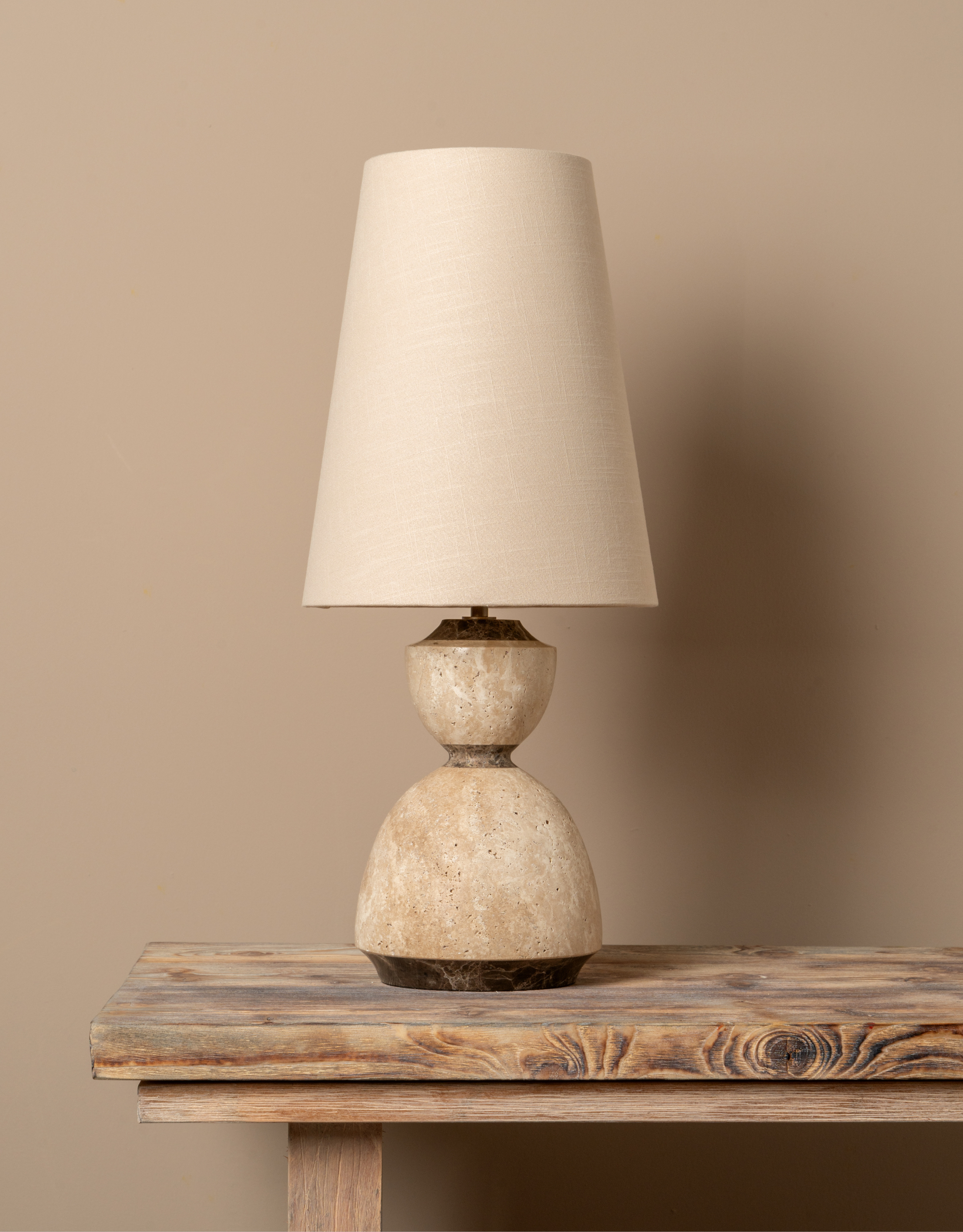 A minimalist table lamp with a curved marble base and a simple shade from lights&amp;amp;lamps