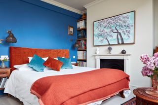 Blue bedroom with orange bed and japanese style art