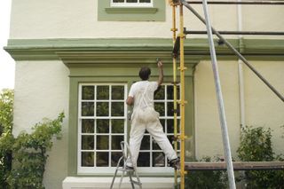 painting the outside of a house with scaffolding