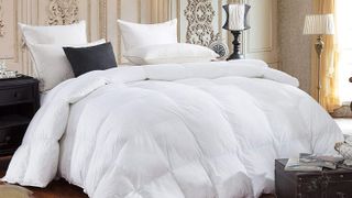 The Egyptian Bedding Siberian Goose Down Comforter shown in an opulent bedroom and surrounded by plump white bed pillows