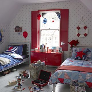 kids room with polka dot wallpaper, wooden flooring and red shutters