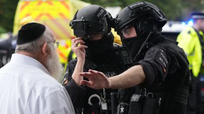 Members of the public talk to police near the Heaton Park Synagogue after a fatal attack earlier today