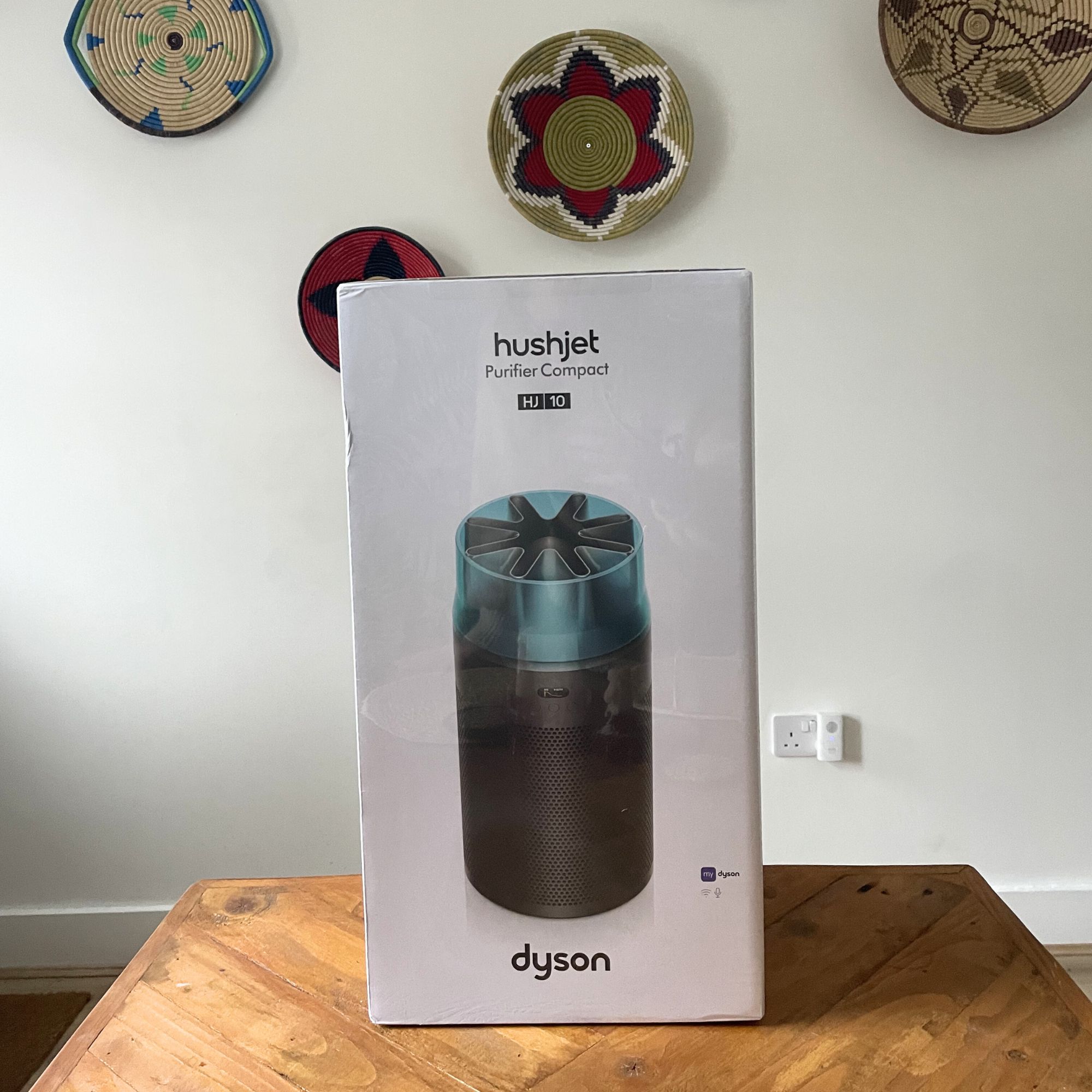 Dyson Hushjet Air Purifier box sitting on a wooden table in front of a white wall