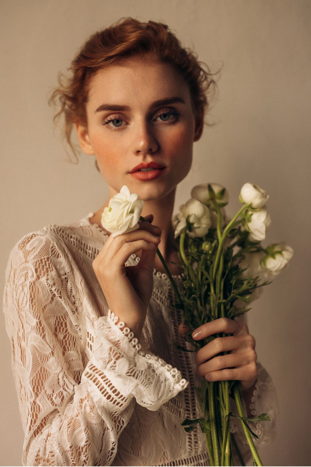 a model in a wedding dress holding a bouquet of ranunculus - wedding beauty timeline