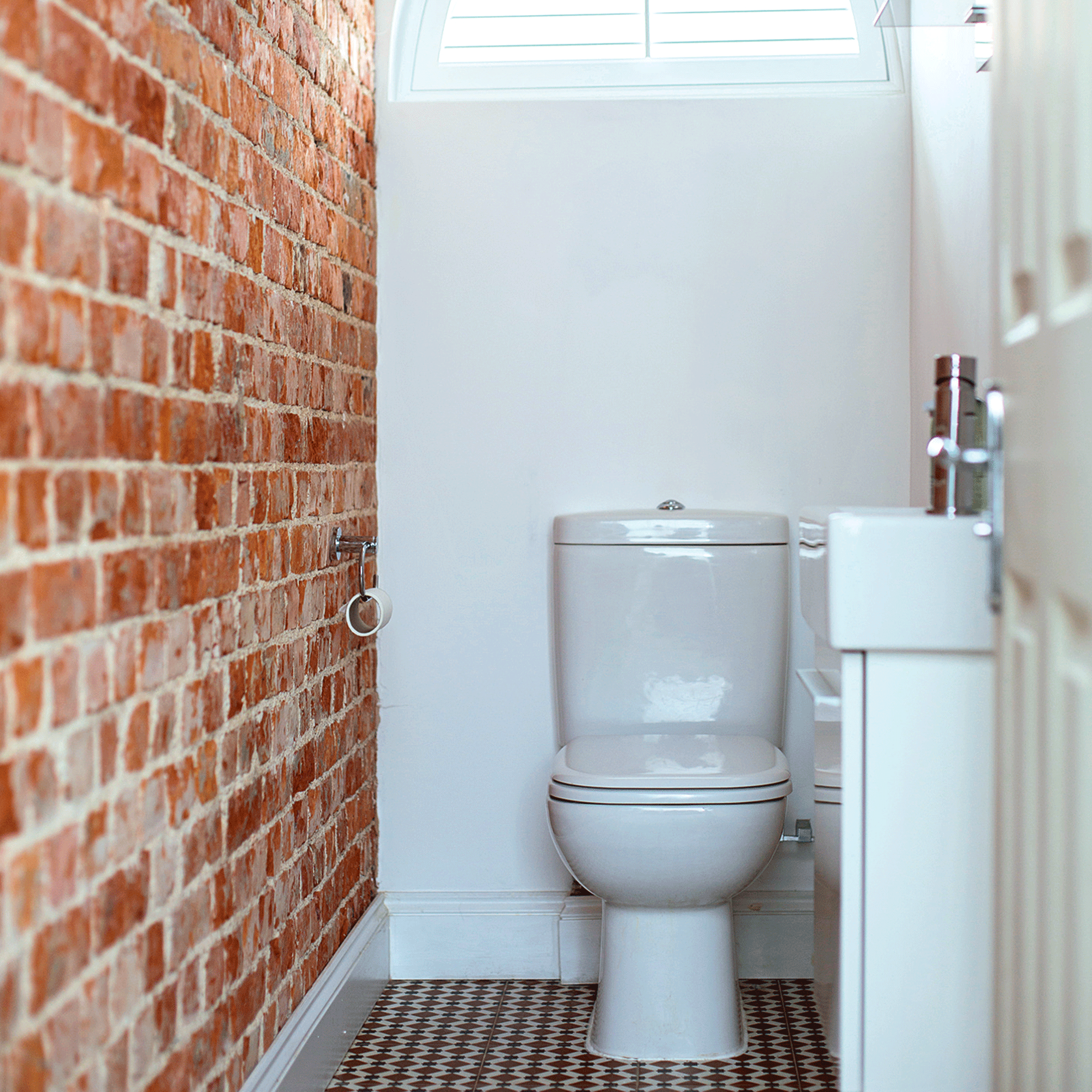 White bathroom with brick wall