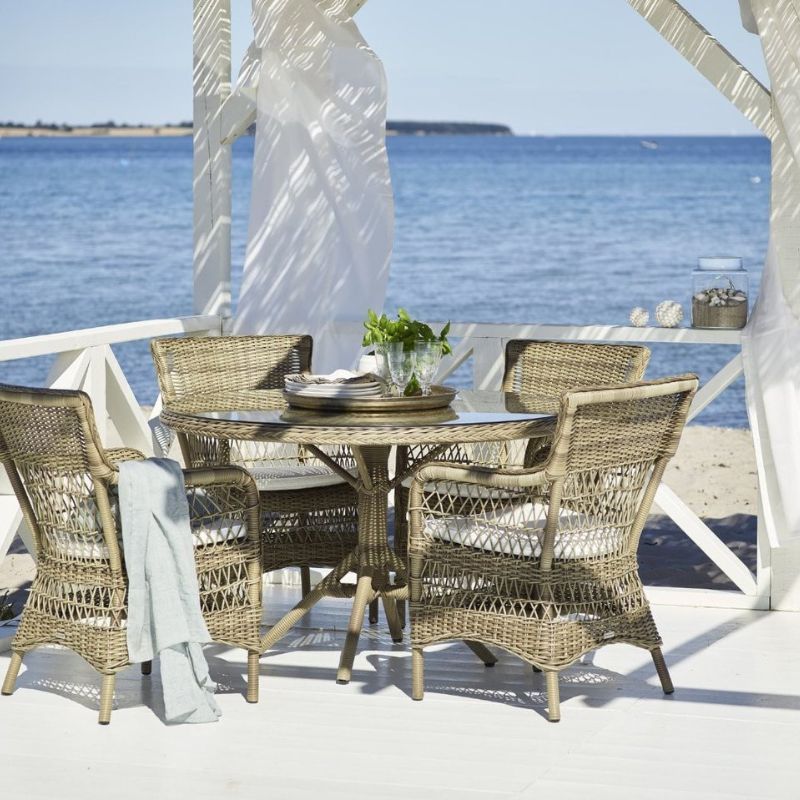 A round Sika Design glass top outdoor dinner table, for the best outdoor furniture brands.