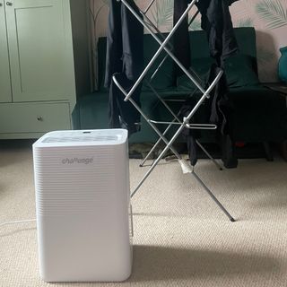 Challenge D015B 12L Dehumidifier sitting in front of a clothes airer full of black clothes