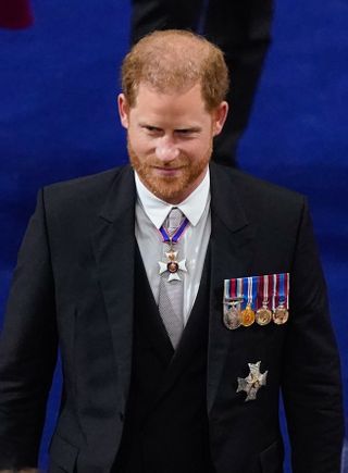 Prince Harry walking inside the Coronation ceremony at Westminster Abbey