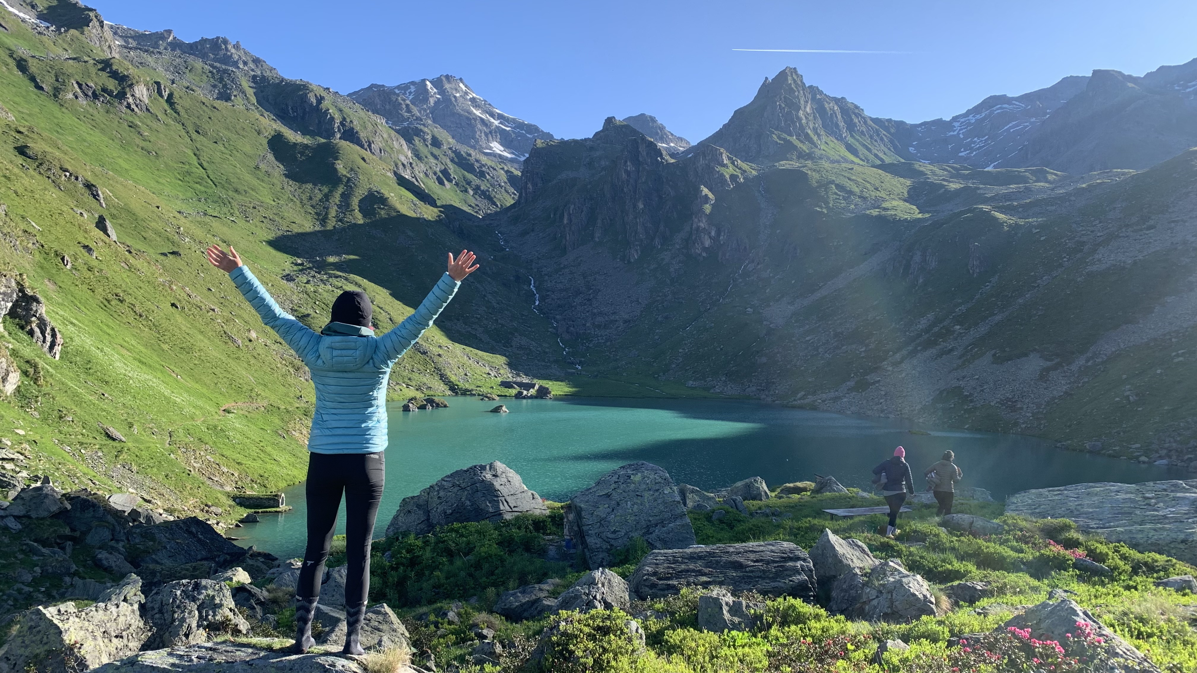 Julia Clarke looking at Lac de Louvie with arms overhead