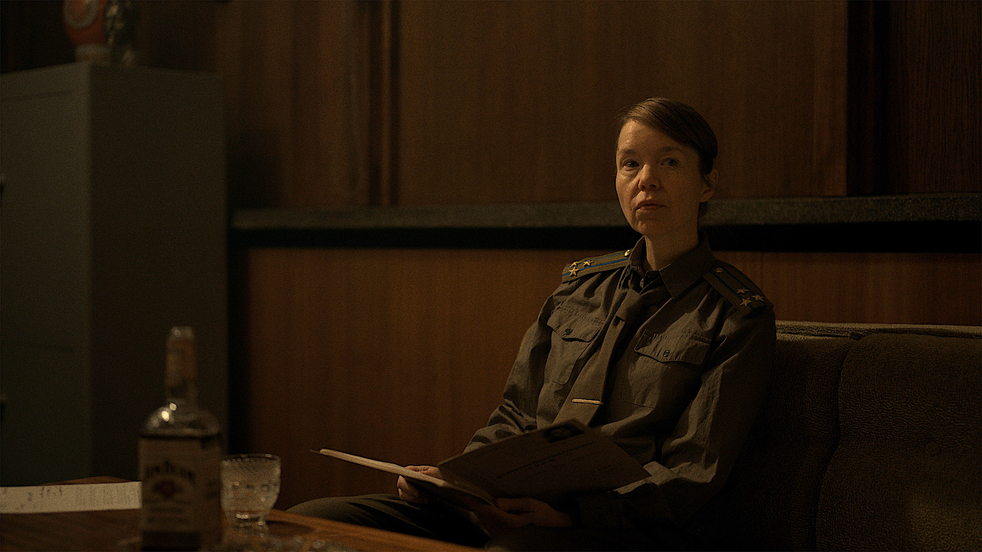 a woman in a military uniform in a dark office