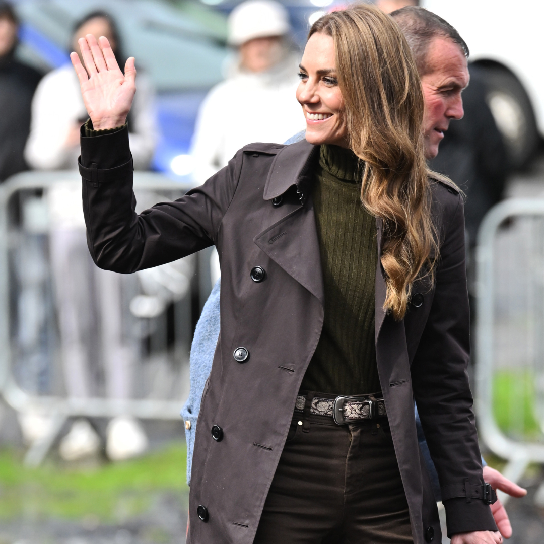 Princess Kate wearing a brown trench and skinny jeans, waving