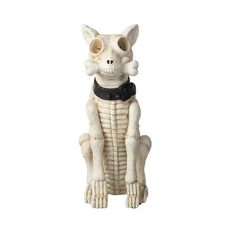 A cream colored skeleton dog statue with a black collar