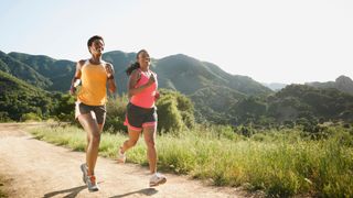 Women in shorts running on a trail