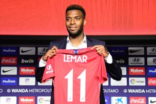 Thomas Lemar poses with an Atletico Madird shirt after signing for the club in 2018.