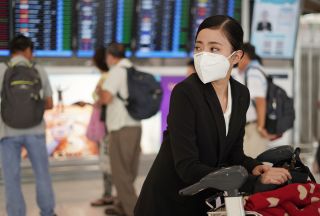 A woman with a face mask at an airport.