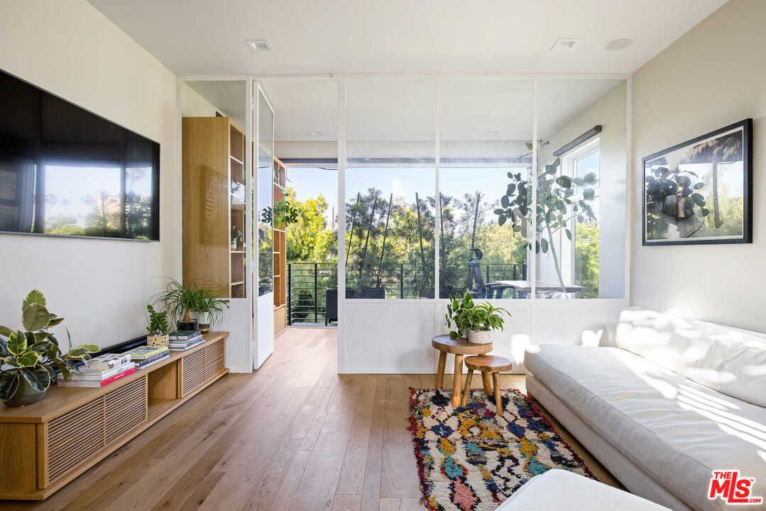 A living space with views of the garden, a white sofa, and a boho style rug