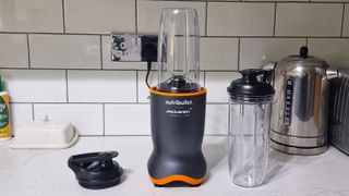 Nutribullet Ultra with blending cups and lids in a white kitchen