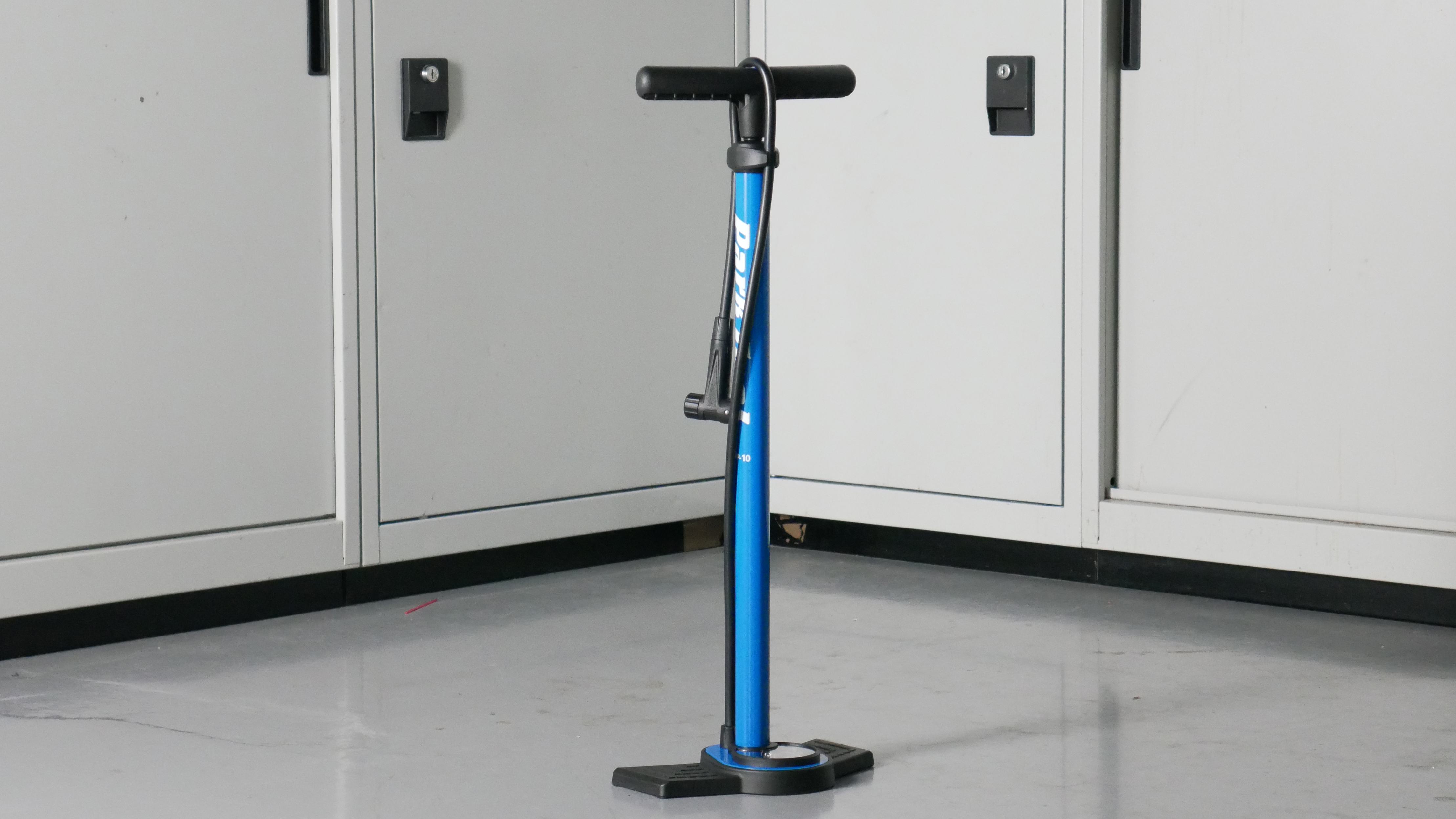 Park Tool bike track pump in blue set to a background of some workshop cabinets