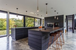 a modern kitchen in black with a double island design