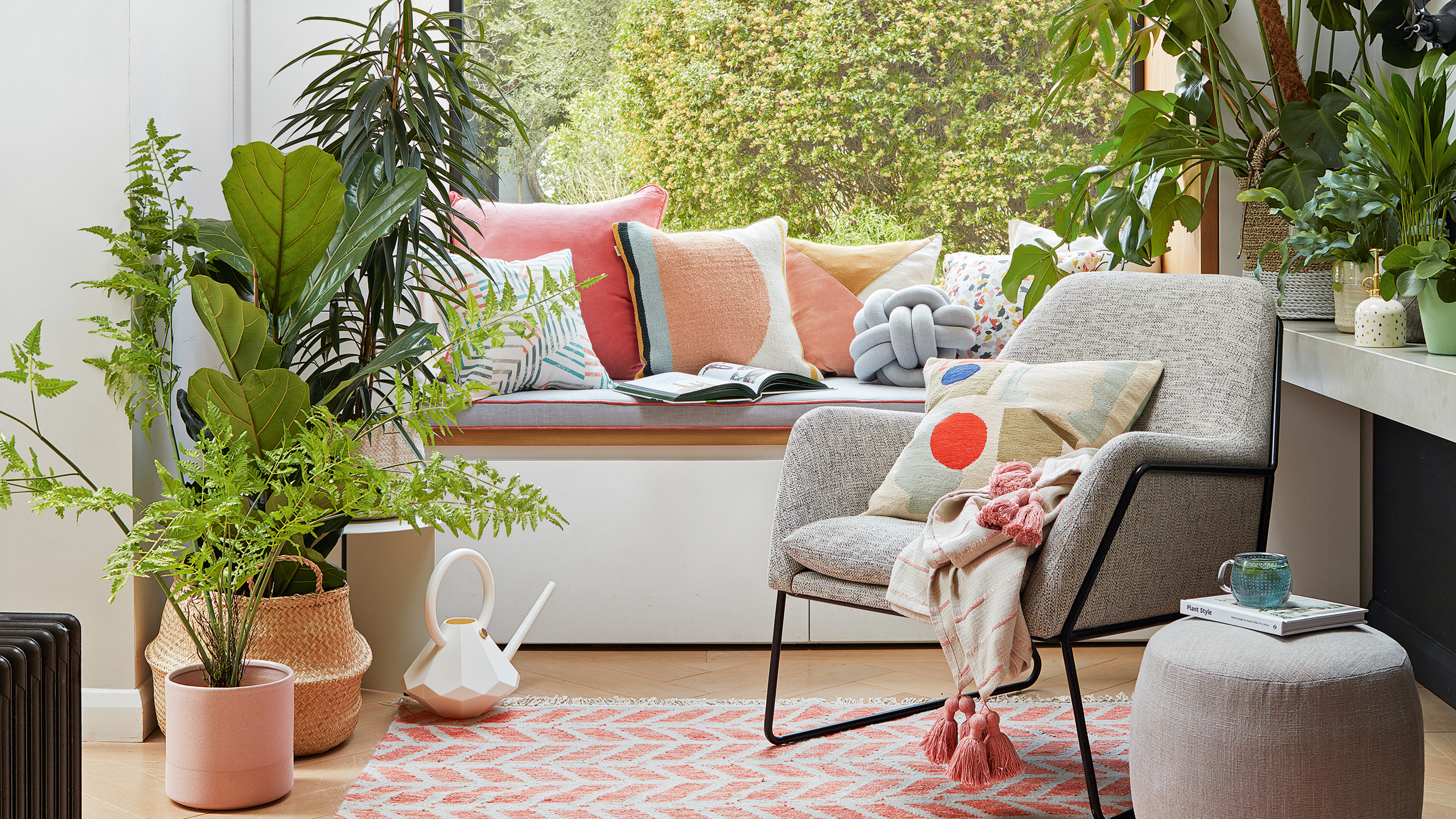 Box window seat with a collection of bright cushions and houseplants