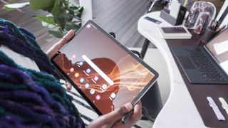 Woman at desk holiding the Samsung Galaxy Tab S8 Ultra