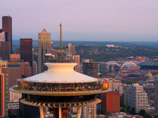A close-up shot of the Space Needle with the city in the backdrop at golden hour.