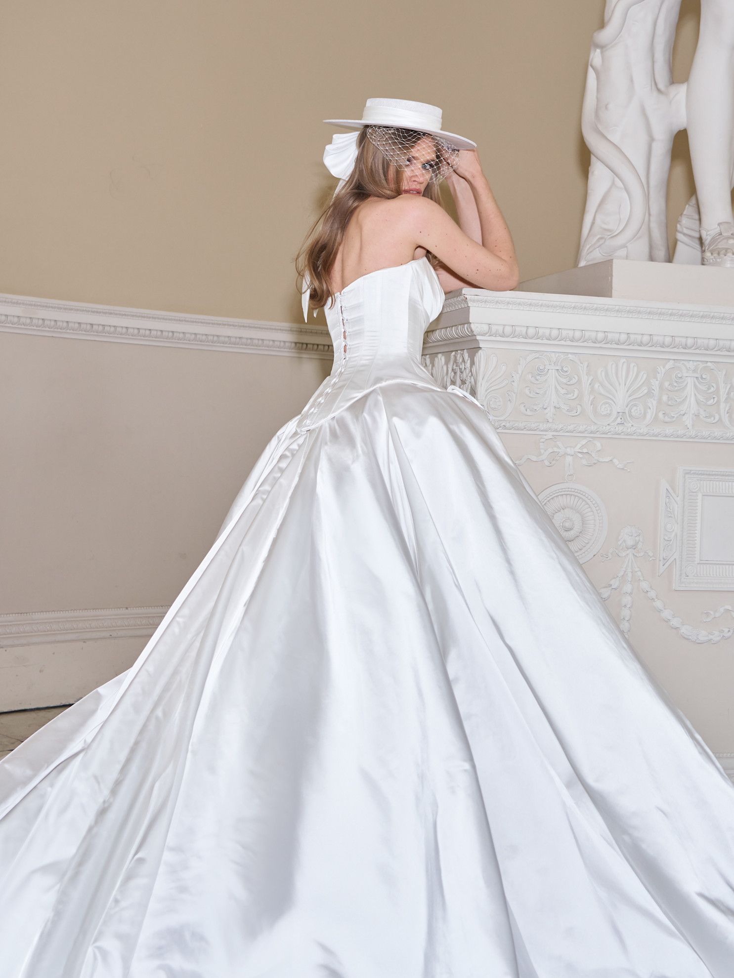 Woman wearing bridal hat, an emerging trend for 2026.
