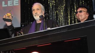 Christopher Lee holds an award onstage with Tony Iommi