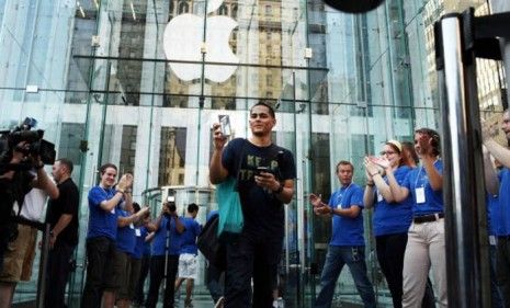 One of the first customers to score an iPhone 4 emerges from the Fifth Avenue Apple Store in New York today.