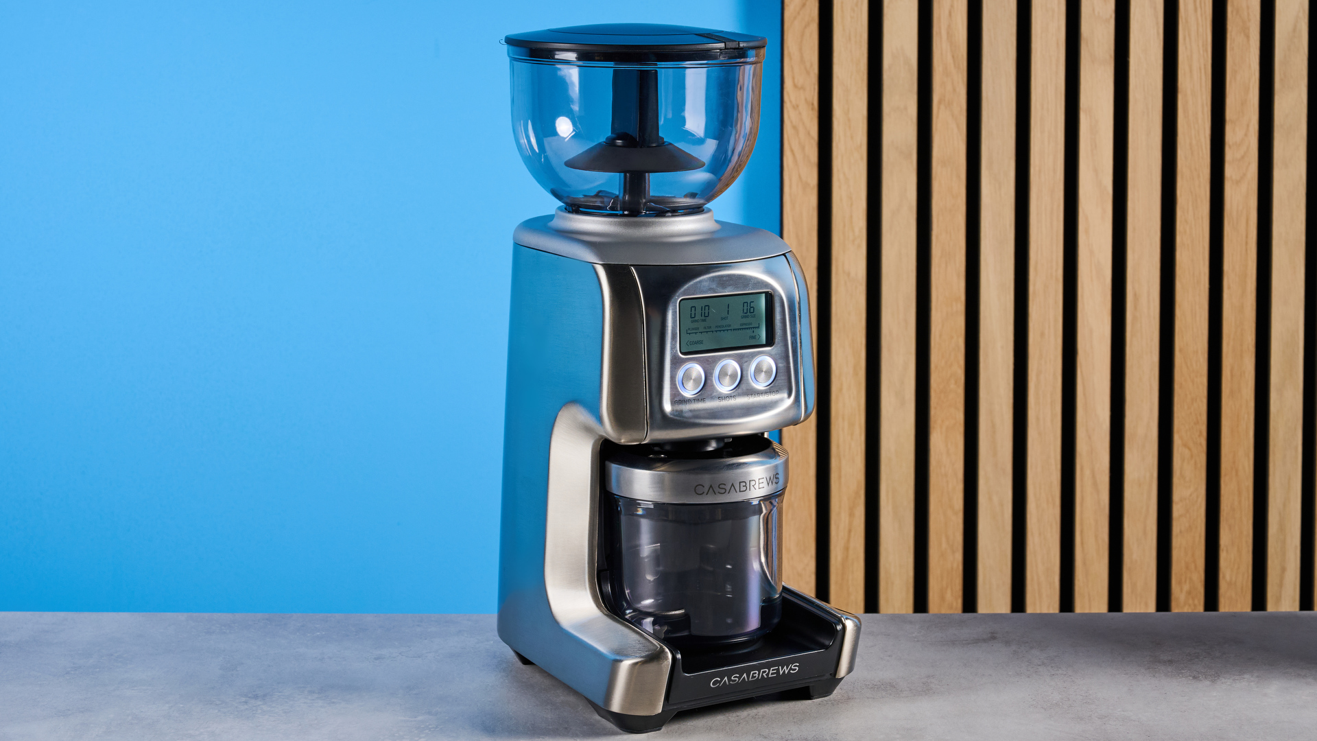 the casabrews tornado coffee grinder in silver showing the LED screen, grind adjustment dial, and photographed against a blue background