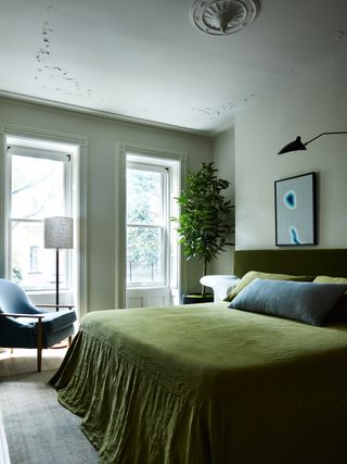 ένα πράσινο υπνοδωμάτιο με σκούρο πράσινο πάπλωμα